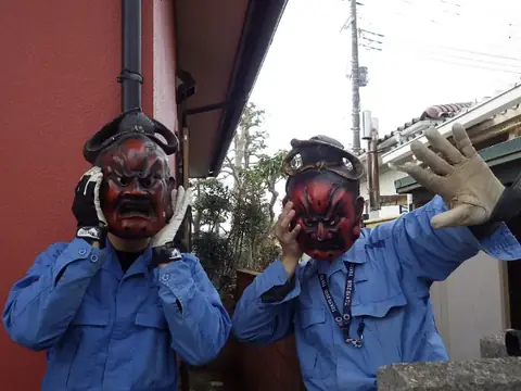 鬼のお面をかぶって記念撮影する作業員2人