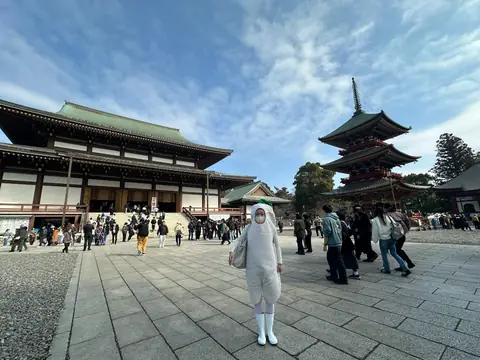 寺の境内を大根の着ぐるみで歩く社員