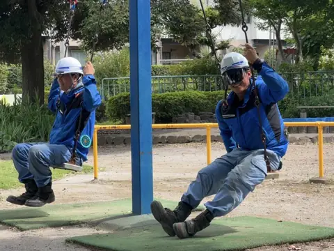 公園でポールを使ってポーズをとる社員2人